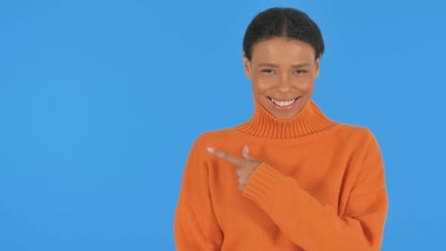 Zeigende Frau zeigt Copyspace auf grünem Hintergrund