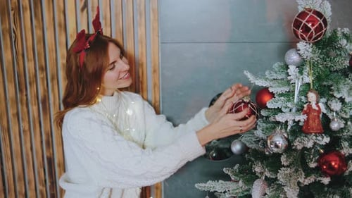 Woman Decorating Christmas Tree in Cozy Home