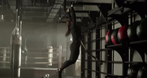 Strong Sportswoman Doing Pull Ups Exercise in Gym