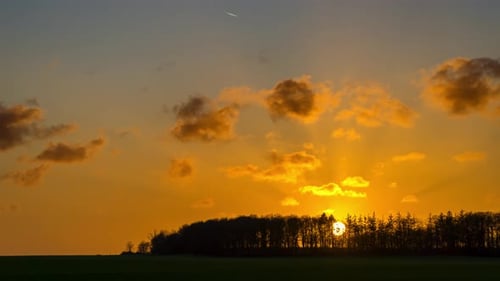 Landscape timelapse with forest, sunset and expressive sky with drifting clouds