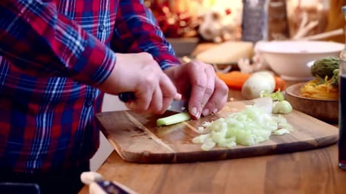 Chopping Fresh Vegetables on Cutting Board in Kitchen