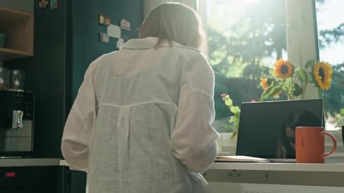 Woman Works at Table with Laptop, Takes Notes