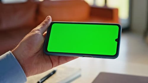 Hand Holding Phone with Green Screen Horizontally