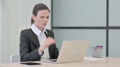 Woman Working at Laptop Massaging Stiff Neck in Office
