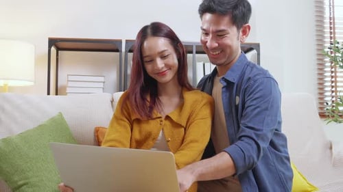 Loving Couple Uses Laptop on Sofa at Home