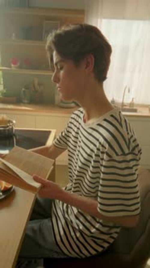 Moving Around Tracking Shot of Caucasian Guy Sitting at Breakfast Table Young Man Putting Orange