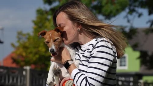 Woman Hugging and Kissing Her Dog