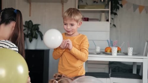 Children Inflating Balloons for a Birthday Party