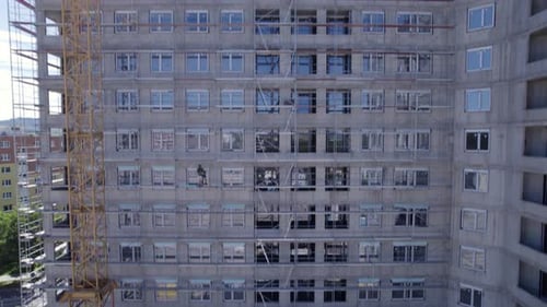Vista lateral de los andamios en la construcción inacabada de un edificio en un clima soleado. Poprad