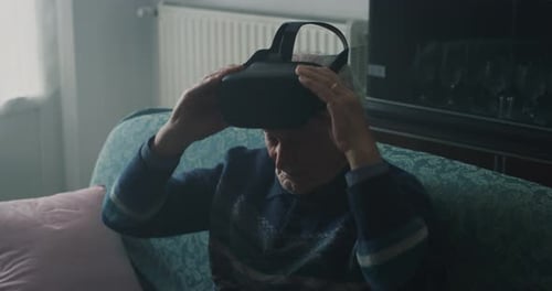 Cinematic close up shot of amazed mature senior man is having fun while using vr glasses in living