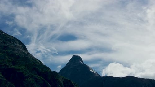 The blue sky on the top of the mountain and the slowly moving clouds.