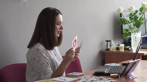 Woman Teaching With Flashcards During Online Lesson