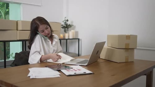 Woman Working in Bright Office While on Phone