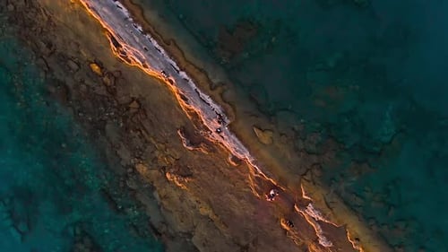 Aerial view of beautiful turquoise water with rocky pier