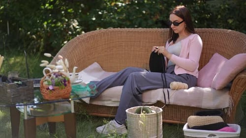 Une femme aime tricoter à l'extérieur dans un jardin magnifiquement relaxant et dynamique