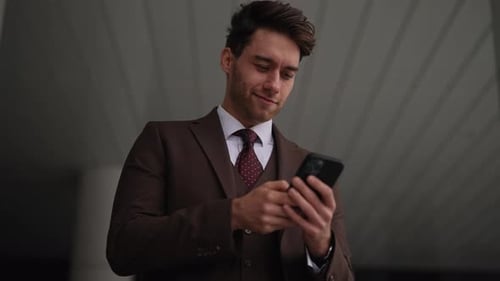 Man in Suit Using Smartphone