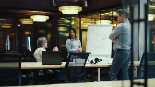 Asian Woman Presenting Blueprint in Office