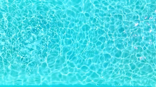 Ralentissement de l'eau bleue dans la piscine avec des reflets lumineux
