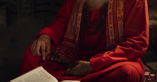 Slow Motion Portrait of Old Indian Monk Reading a Book in an Ancient Temple. Senior Guru G