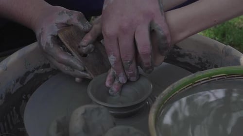 Hands Forming Clay Bowl on Potter's Wheel