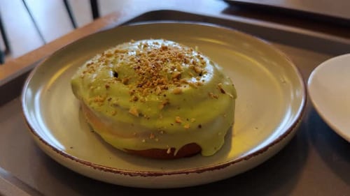 Delicious Sweet Mini Cake Sprinkled with Pistachios in a Bakery Fresh Bun with Cream Filling and