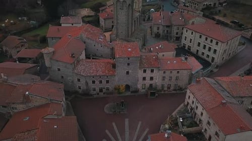 aerial shot over the town of Marols in Loire departement on an overcast day revealing the fortified