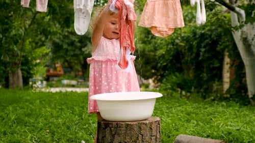 The Child is Washing Clothes in the Garden Selective Focus