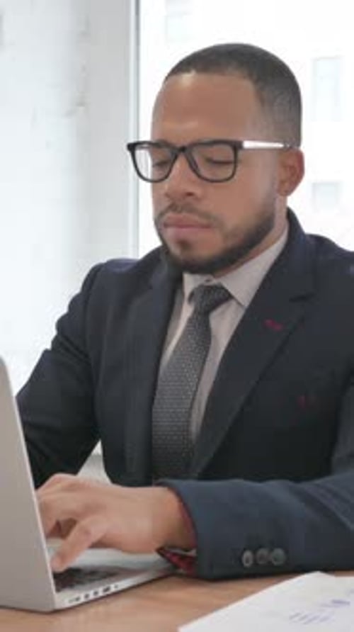 Business Man Typing on Laptop at Desk Indoors