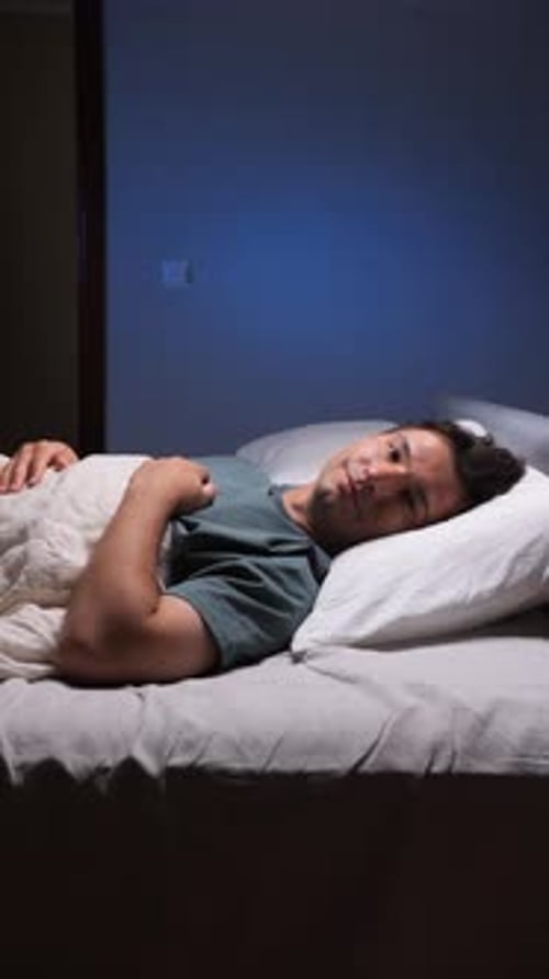 Vertical Video Man Sleeping Peacefully in Bed at Night