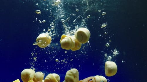 Raw Dumplings Fall Down Into Clear Water Slow Motion Closeup