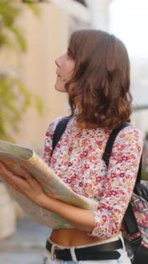 Young Woman Traveler Looking at Map on City Street
