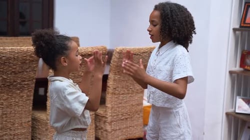 Garotas inter-raciais brincam de contar rimas na sala de estar e cantam