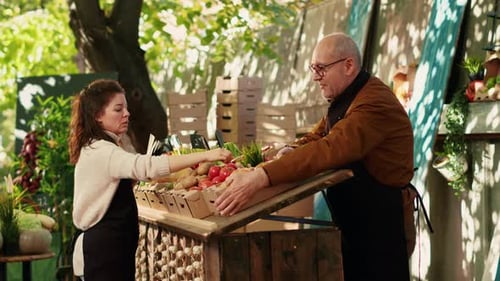 Female Happy Vendor Putting Price Tags on Veggies Boxes at Farm Market