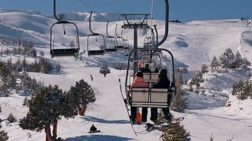 Gente en telesilla de esquí sobre una ladera nevada en Sunny Winter Resort