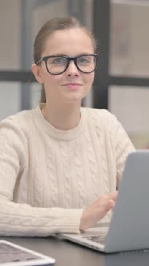 Young Woman Smiling at Camera in Office