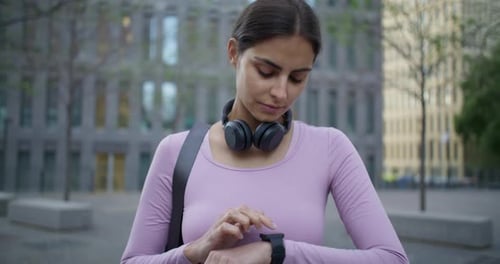 Young Woman Using Smartwatch in Urban Setting