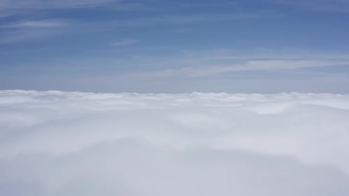 A stunning drone shot, a drone ascends through clouds at a high altitude, California