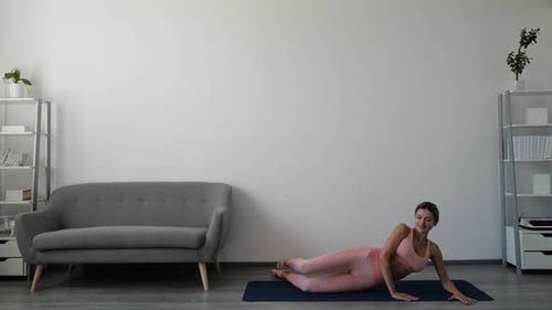 Young Woman Doing Leg Lifts on Yoga Mat
