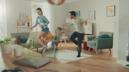 Young Couple Dancing Together in Living Room at Home