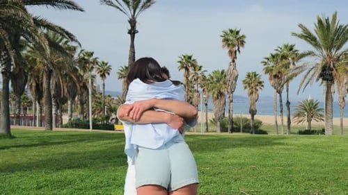 Happy Couple Embrace in a Sunny Palm Tree Park