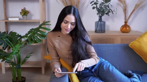 Woman Relaxing on Couch With Tablet