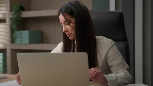 Woman Working on Laptop at Office Desk