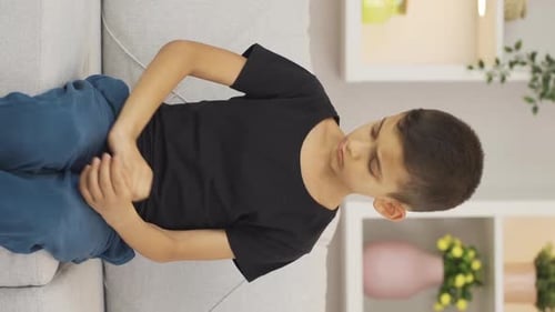 Boy Scratching Itchy Arm and Neck at Home