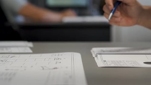 Close up static shot of hands of male mechanical engineer, designers discuss problems on blueprints.