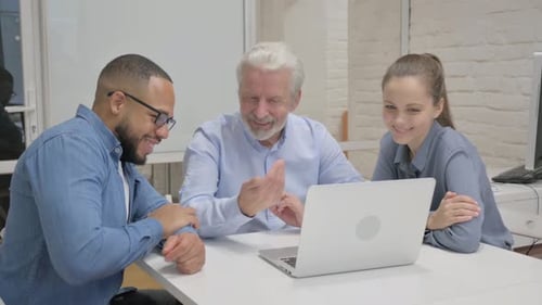 Colleagues Meeting Around a Laptop in Office