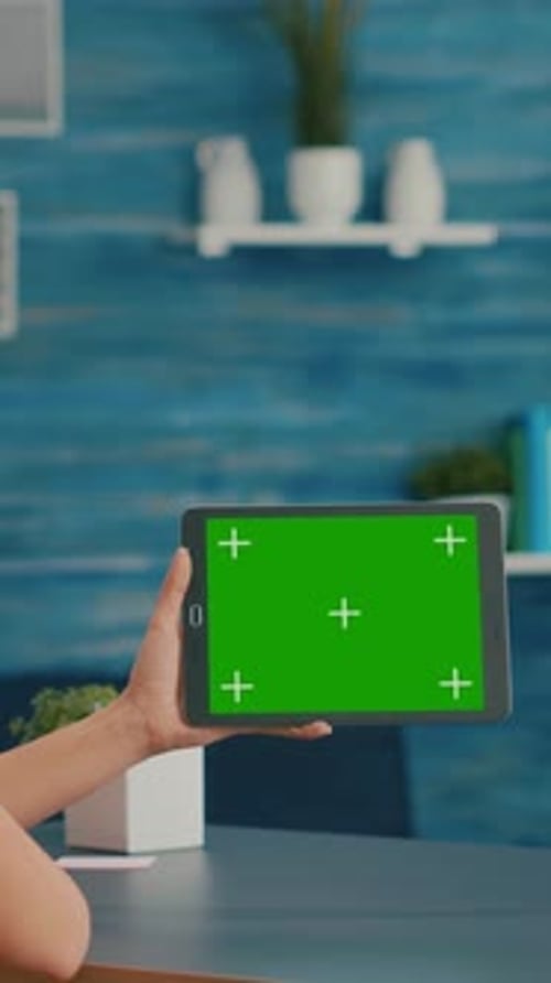 Vertical Video Woman Looking at Tablet Computer with Mock Up Green Screen