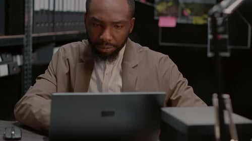 Man Works on Laptop and Drinks Coffee
