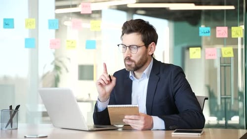 Man in Suit Taking Notes at Modern Office Desk