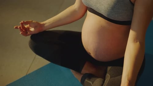 Pregnant Woman Meditating on Yoga Mat at Home