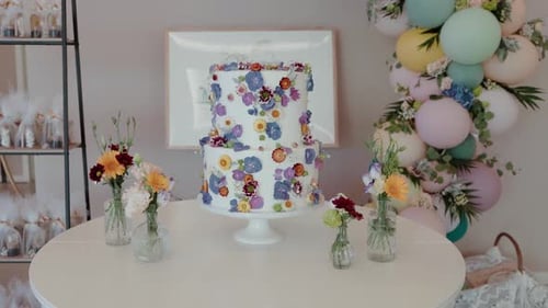 Birthday cake on table with balloon decoration indoors